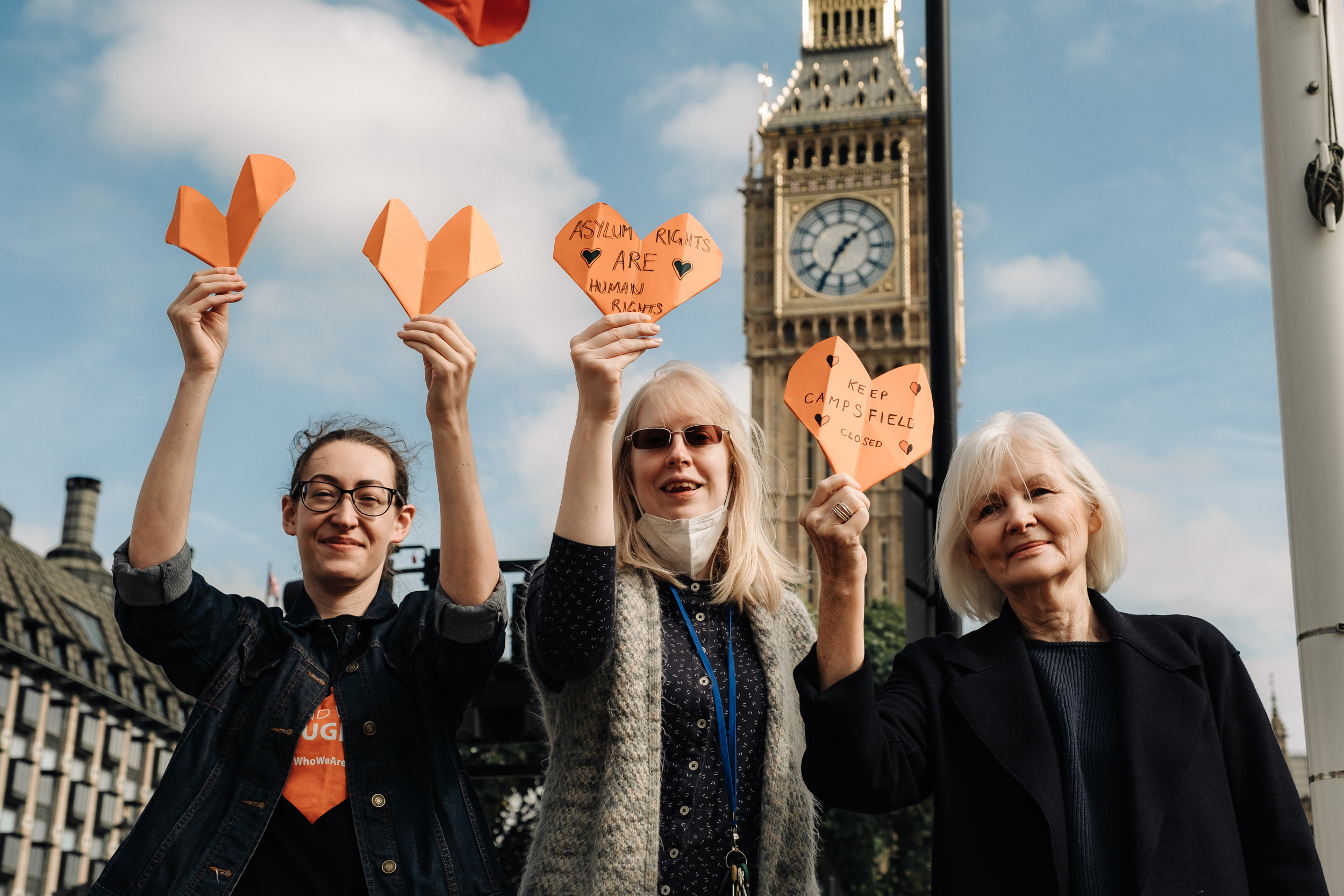Campaigners with orange hearts in front of Houses of Parliament